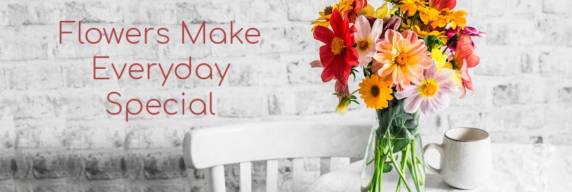 Table with coffee cup and fresh vased flowers because Flowers Make Everyday Special